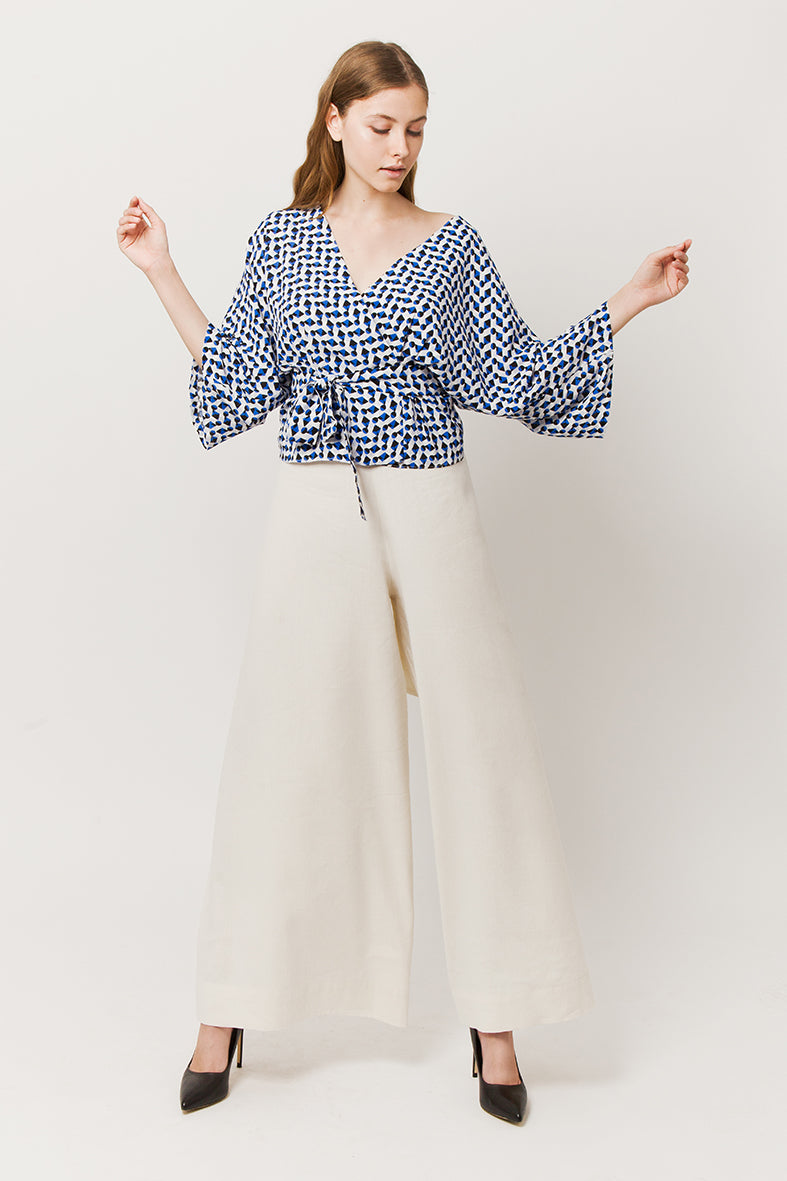 Model in tiche total look - blue wrapover kimono top and white pants