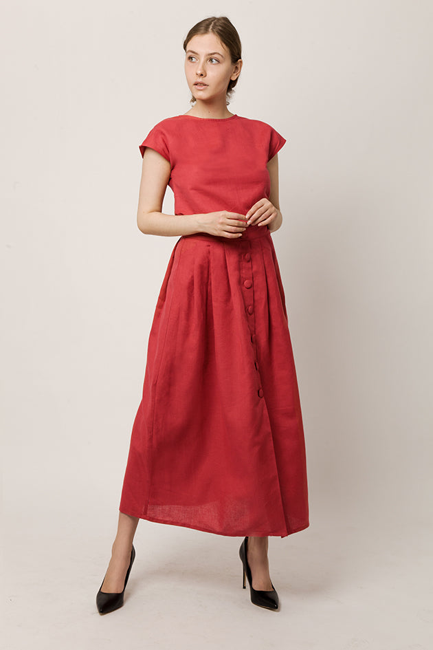 Model in cap-sleeve top in a deep-red color and long skirt