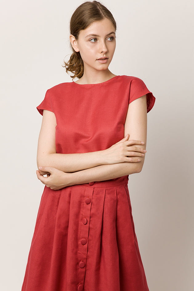 Model in cap-sleeve top in a deep-red color and long skirt