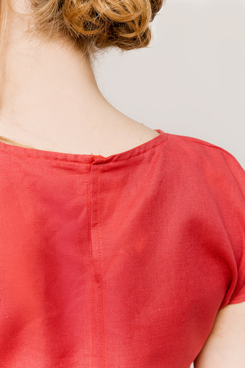 A detail of a  cap-sleeve top in a deep-red color
